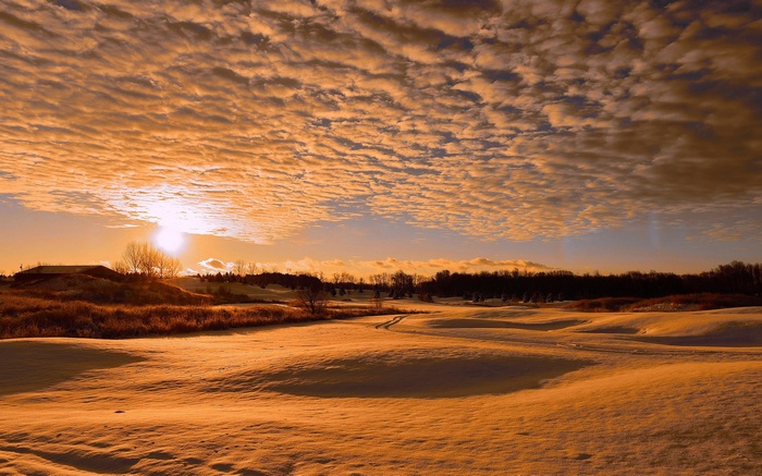 Snowy landscape with dramatic sunset clouds