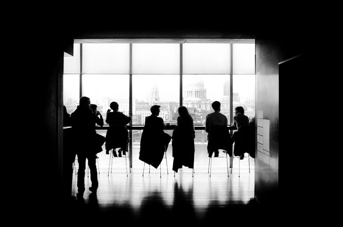 People Silhouetted at a Window Overlooking a City