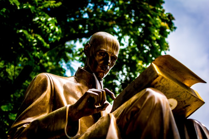 Bronze statue of a man reading a book