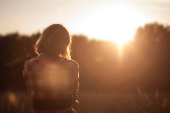 Woman in red plaid shirt watching sunset