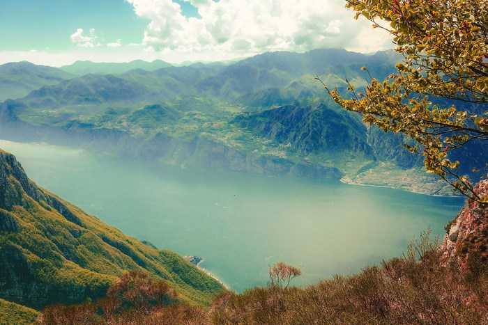 Mountain lake view with trees and clouds