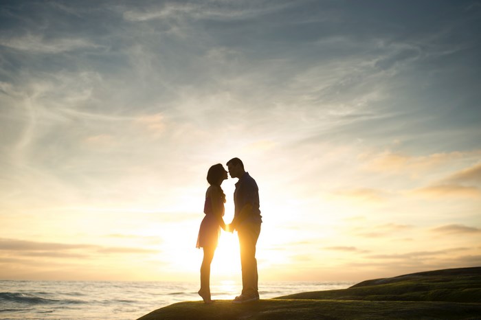 Silhouette of Romantic Couple Kissing at Sunset