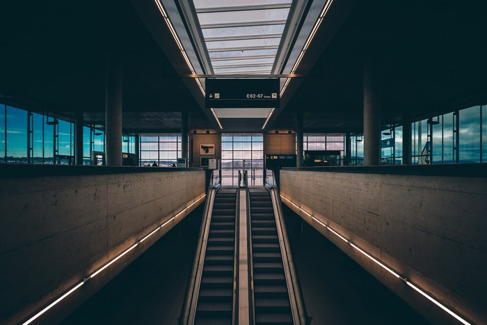 Modern airport interior with escalators and large windows