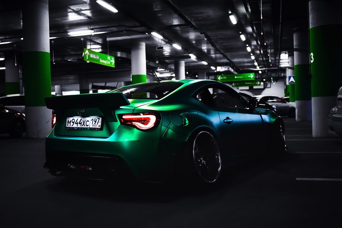 Green Toyota sports car in a parking garage