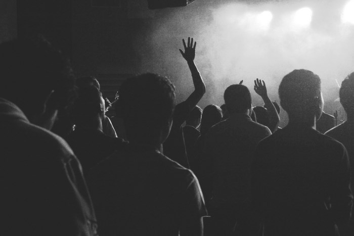 Audience with hands raised at a concert