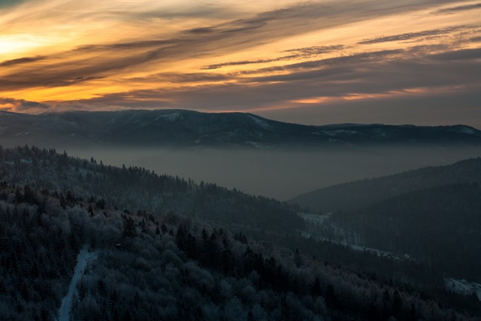 Winter mountain range at sunrise with fog