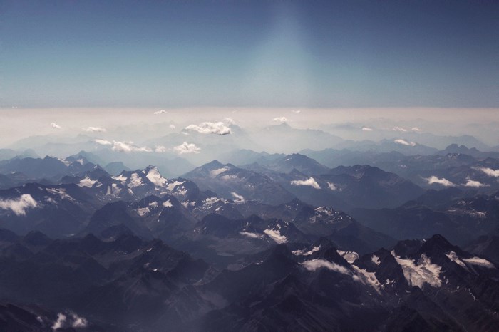 Aerial view of a vast mountain range under a blue sky