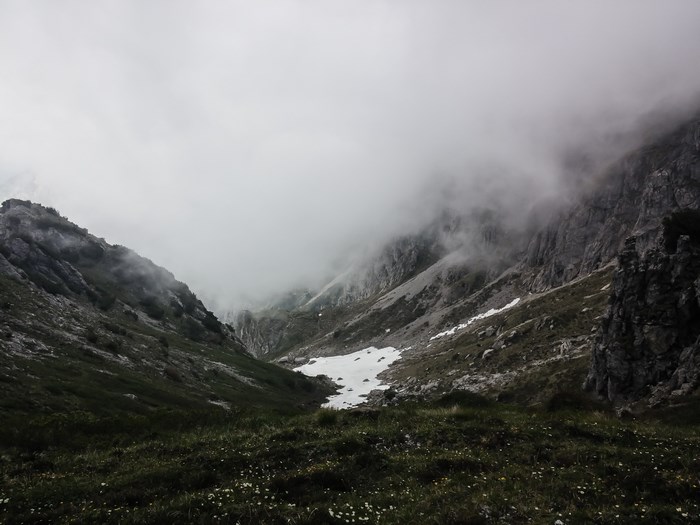 Foggy Mountain Valley with Snow Patches