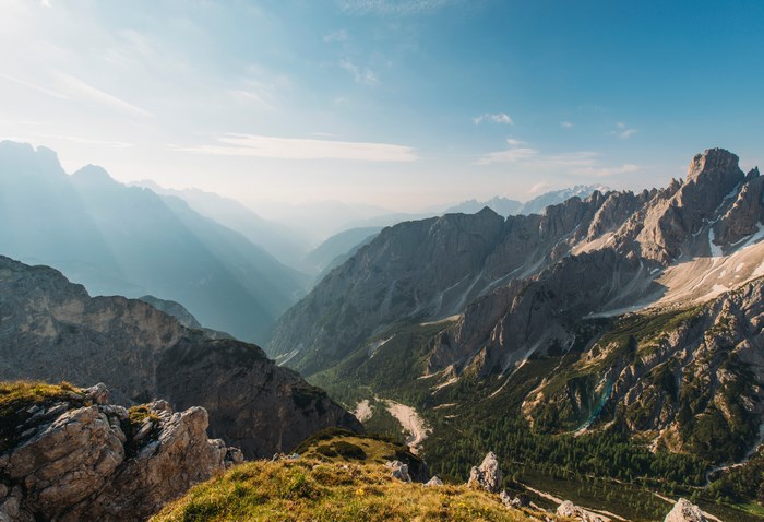 Mountain valley landscape with sunlit peaks and trees