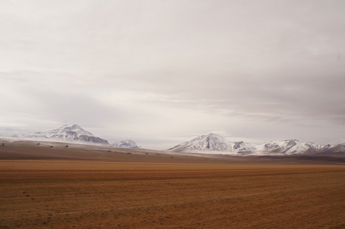 Snow-capped mountains in a vast, empty landscape