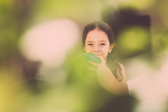 Girl holding a green balloon
