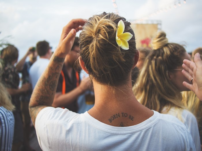 Man with flower in hair and tattoo at outdoor event