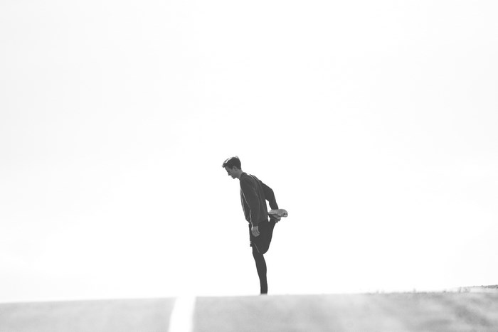 Man stretching on a road