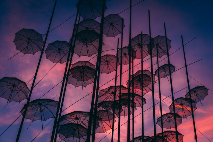 Umbrella installation against a colorful sunset sky in Thessaloniki
