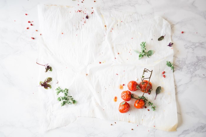 Roasted cherry tomatoes with herbs on baking paper