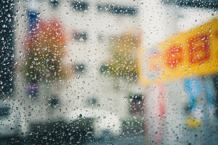 Raindrops on a window with blurred city background