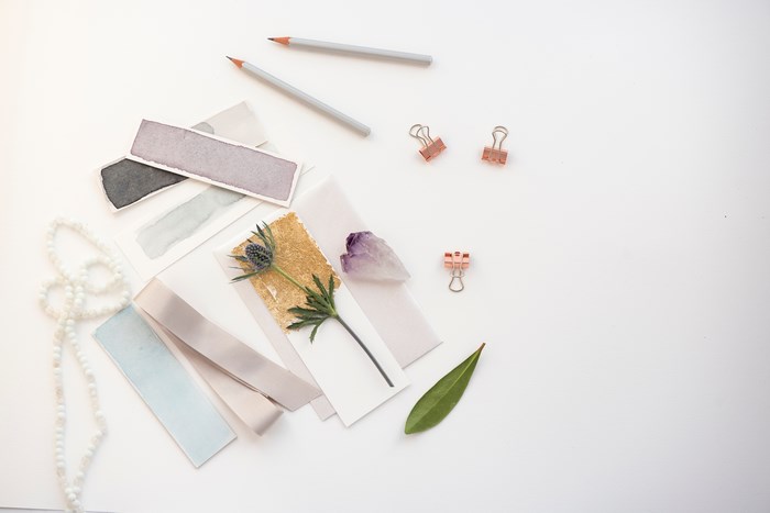 Flat lay of stationery, flowers, and beads