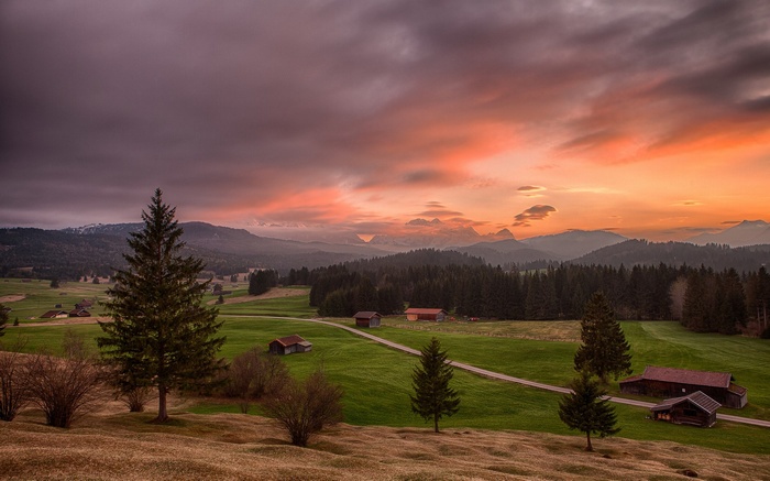 Sunset over a rural landscape with mountains and trees