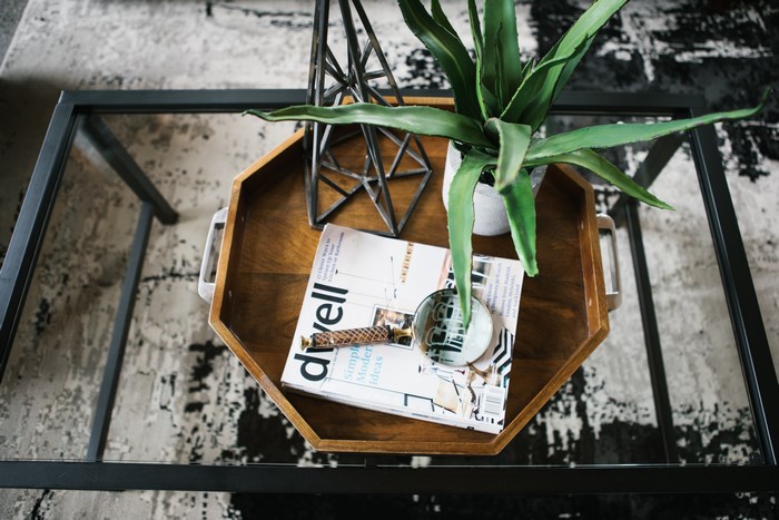 Dwell magazine on a wooden tray with a plant