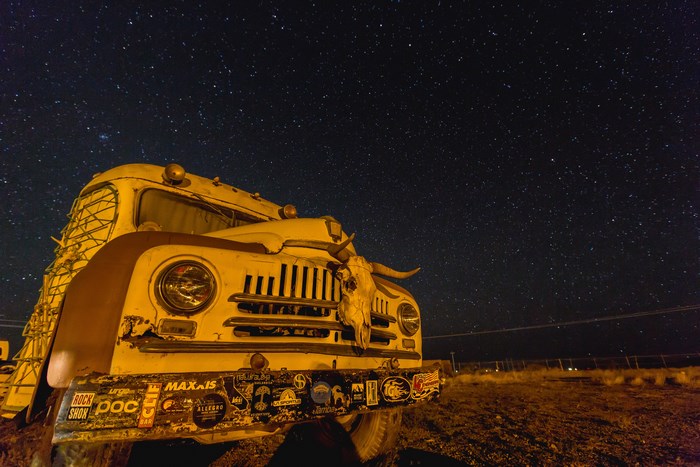 Old school bus with cow skull under starry sky
