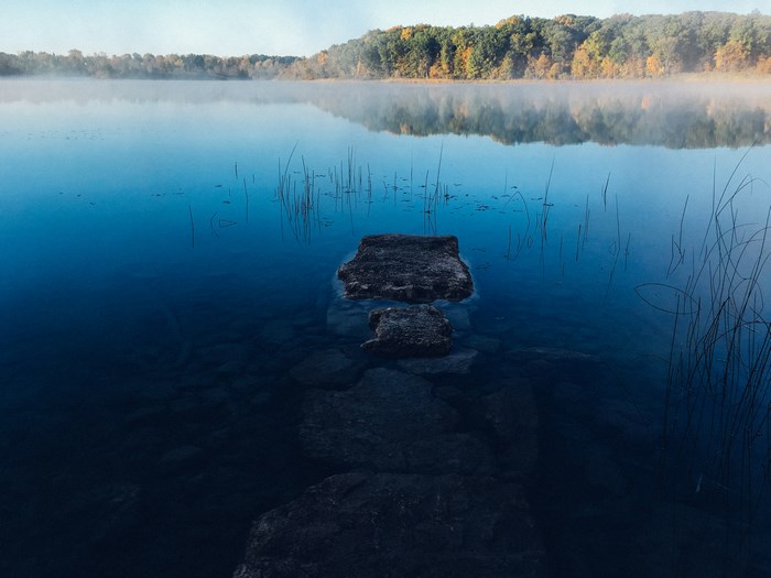 Misty lake with rocks and trees in the background