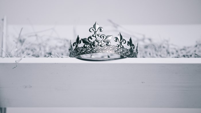 Silver crown on a white wooden surface