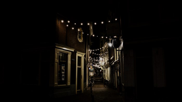 Cozy Narrow Alleyway with Warm Hanging Lights at Night