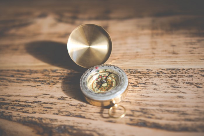 Brass compass on a wooden table