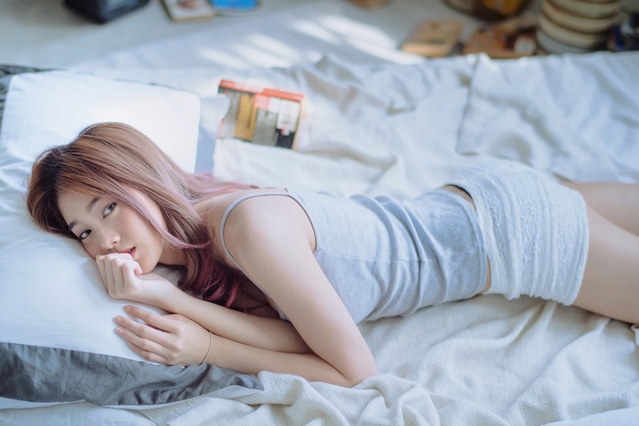 Asian woman lying on a bed