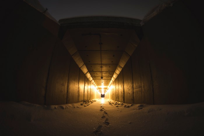 Footsteps in a snowy tunnel with hanging lights