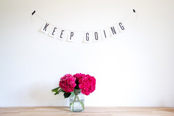 Keep Going banner with pink hydrangeas on a wooden table