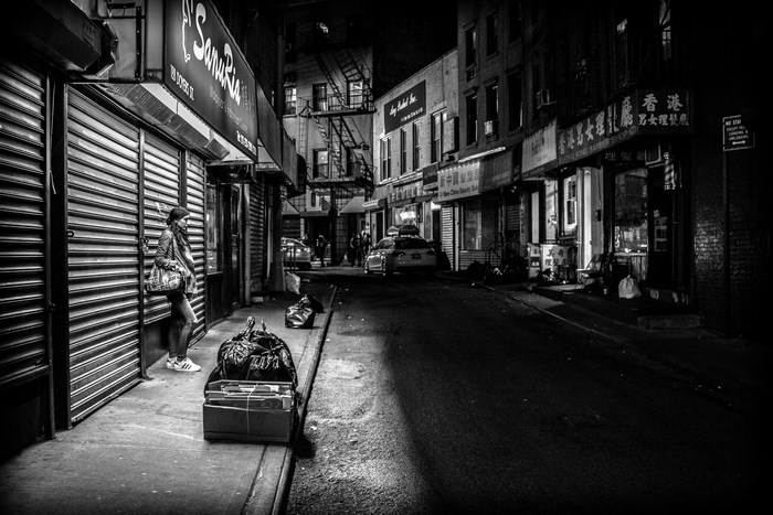Woman waiting on a city street at night