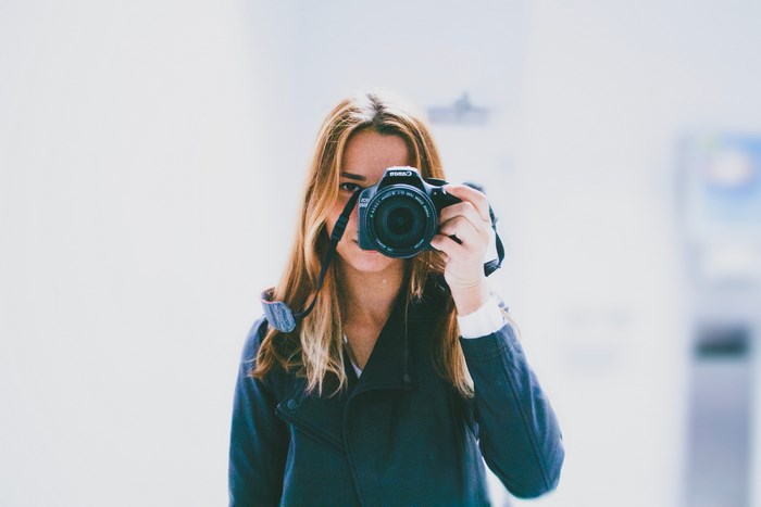 Woman taking a selfie with a Canon camera