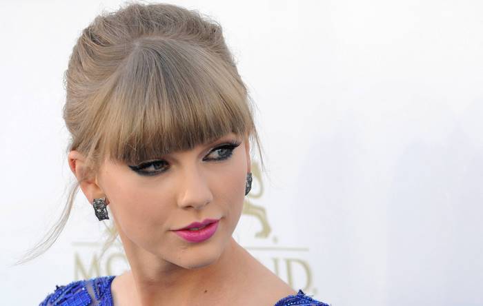 Taylor Swift wearing blue dress and earrings