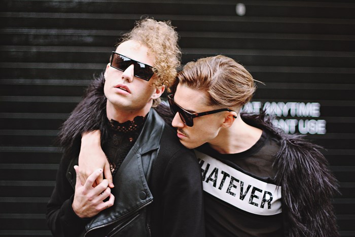 Two men holding hands in street fashion