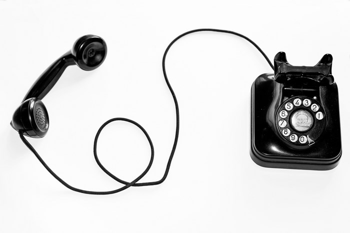 Black rotary telephone with handset off the hook