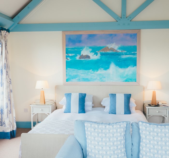 Coastal bedroom with ocean painting and blue accents