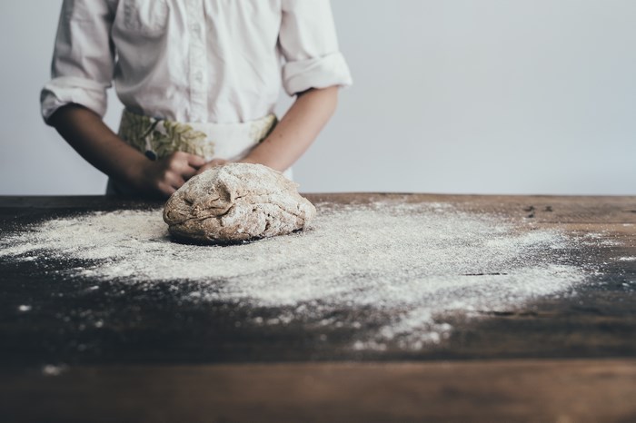 Person with dough on a wooden table