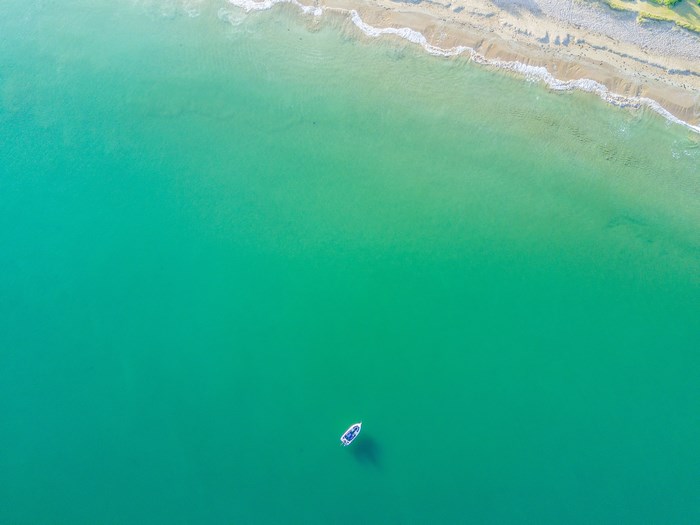 Aerial view of a boat anchored near a sandy beach