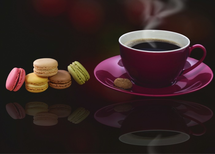 Coffee cup with macarons and reflection