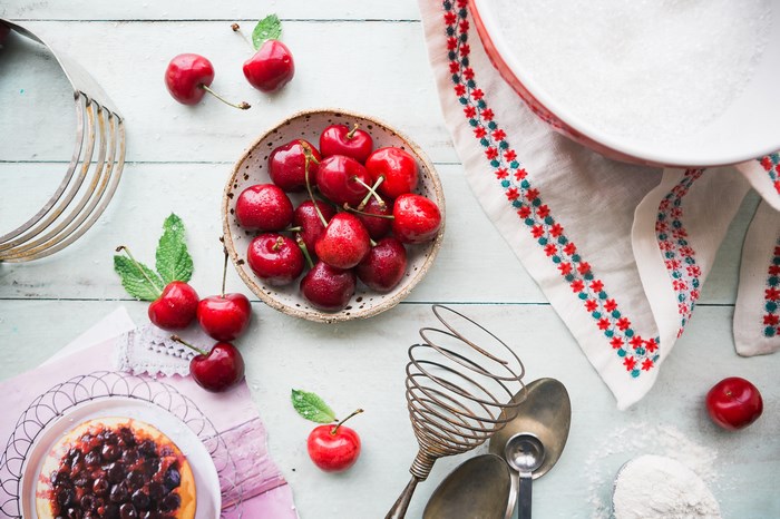 Cherries and baking ingredients on a wooden table