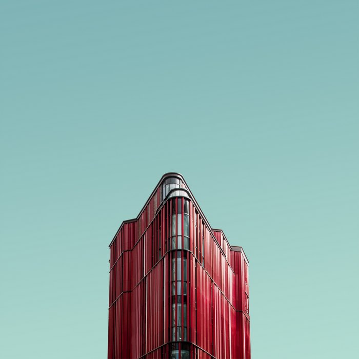 Modern red building facade against a clear blue sky