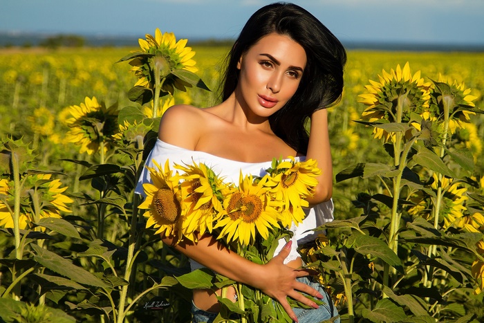 Woman holding sunflowers in a field
