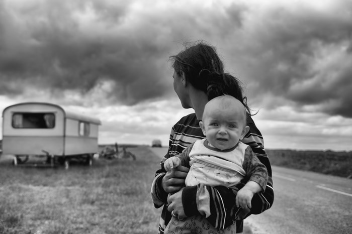 Mother holding baby near trailer in Normandy, France