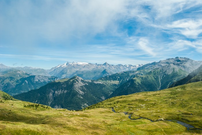 Mountain range with snow-capped peaks under a blue sky