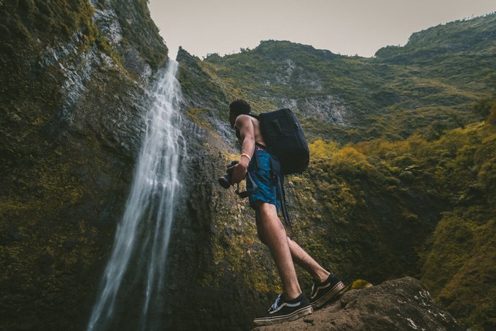 Man with camera at a waterfall in Kauai