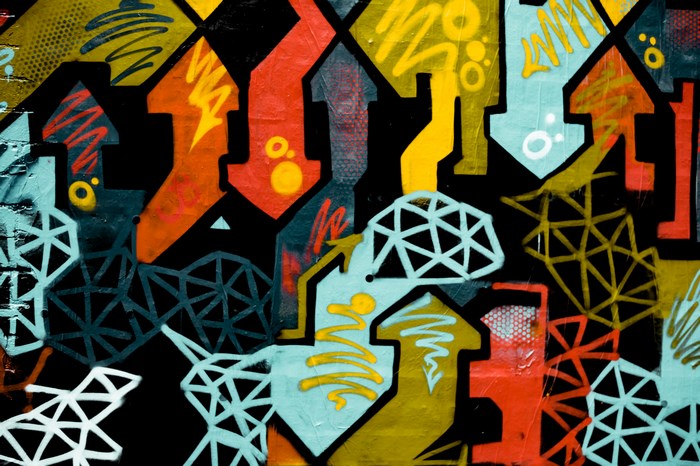 Graffiti mural with arrows and geometric patterns