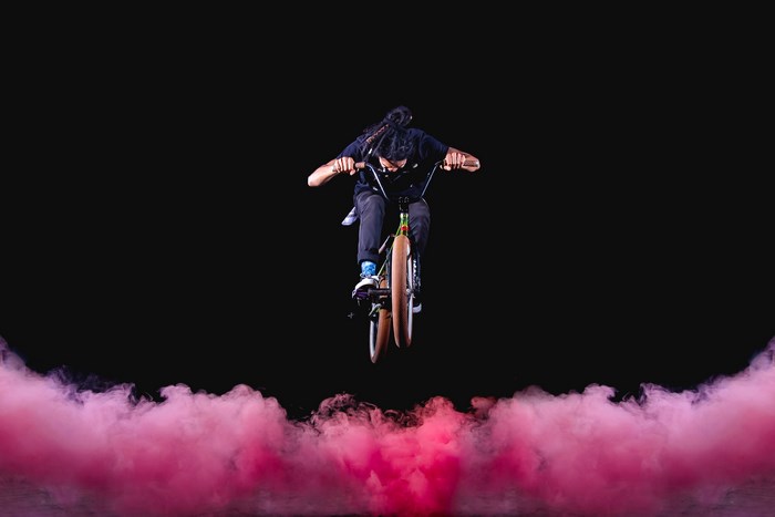 BMX rider performing a trick with pink smoke