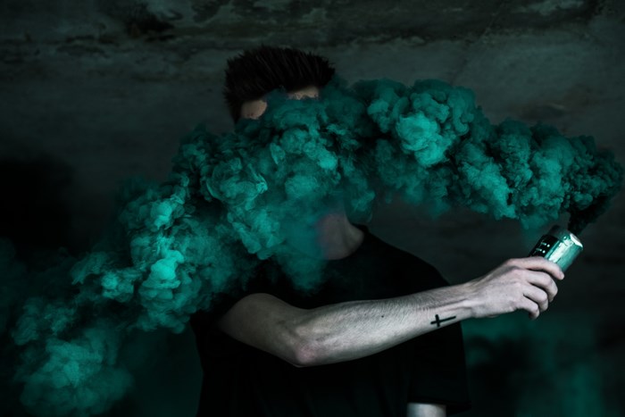 Man holding a green smoke bomb