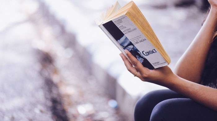 Person reading Carl Sagan's Contact novel